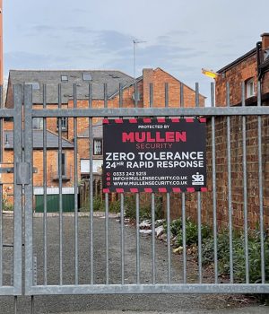 Metal gates of industrial unit with red and black security sign Metal gates of industrial unit with red and black security sign